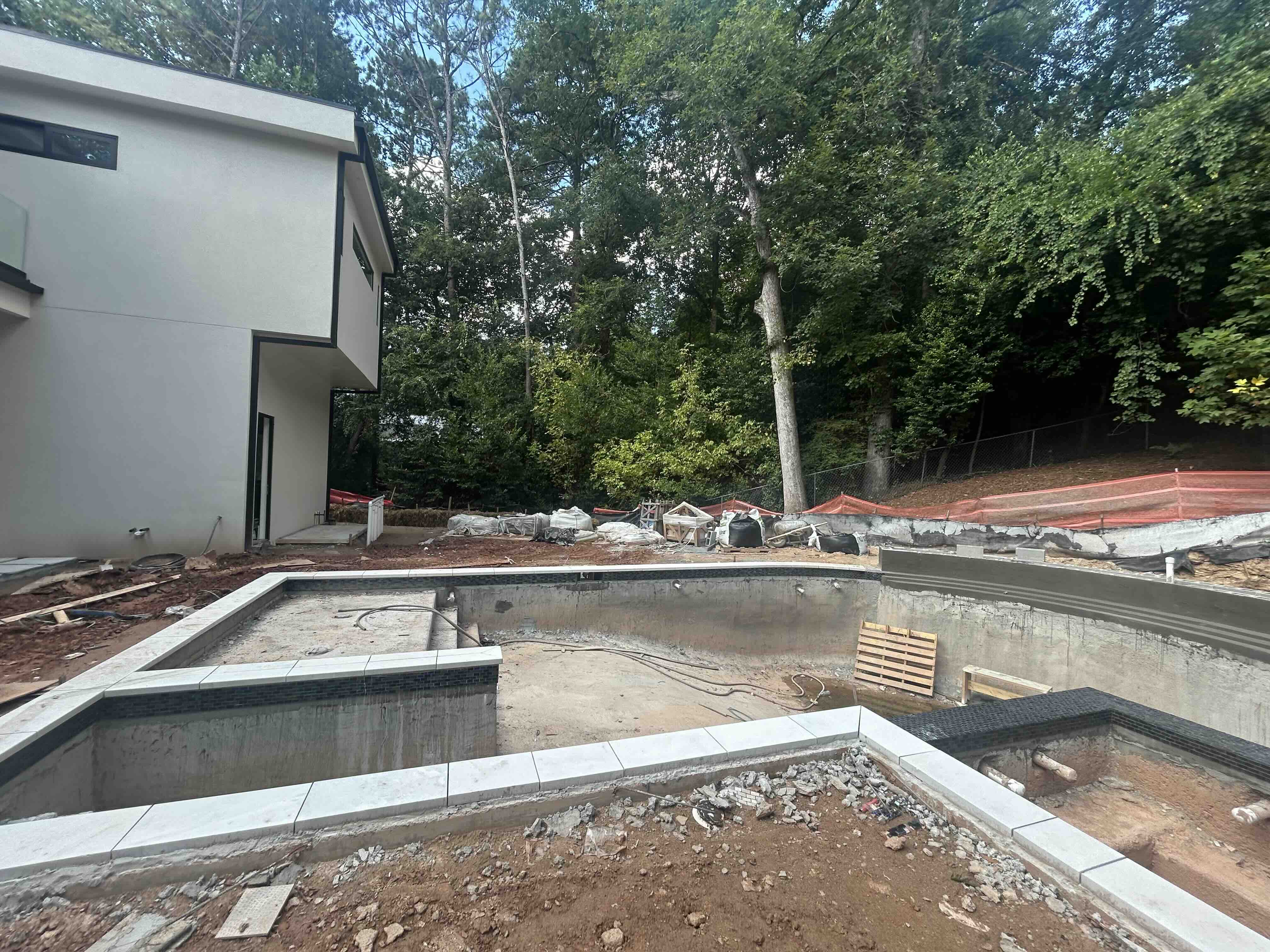Custom pool under construction showing gunite shell and spa structure at a modern Atlanta home