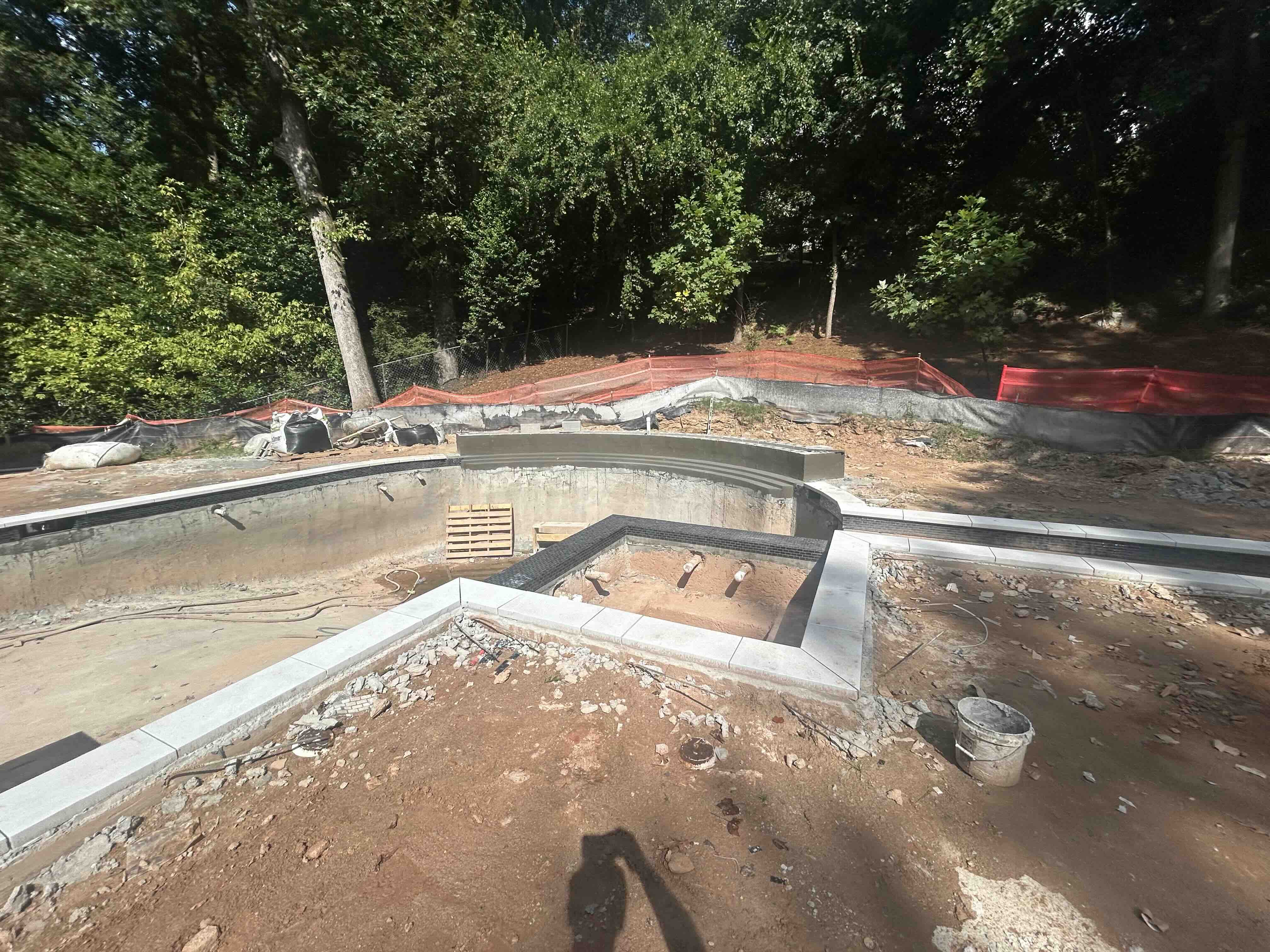 Pool spa with black tile and stone coping being set during construction in Metro Atlanta