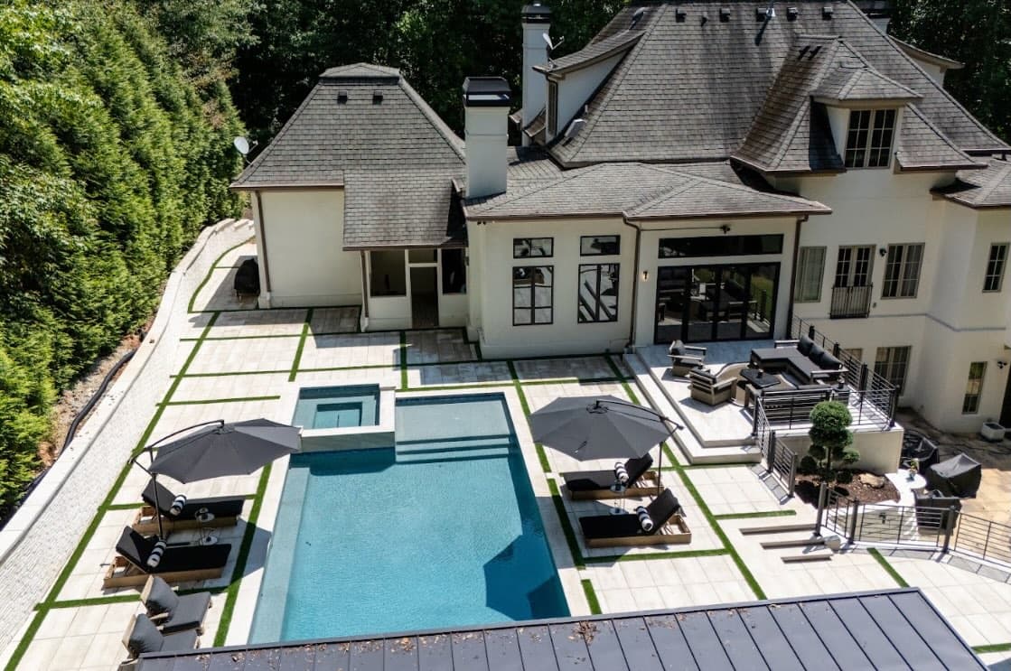 Aerial view of the Buckhead home, geometric pool, spa, and landscaped outdoor living areas