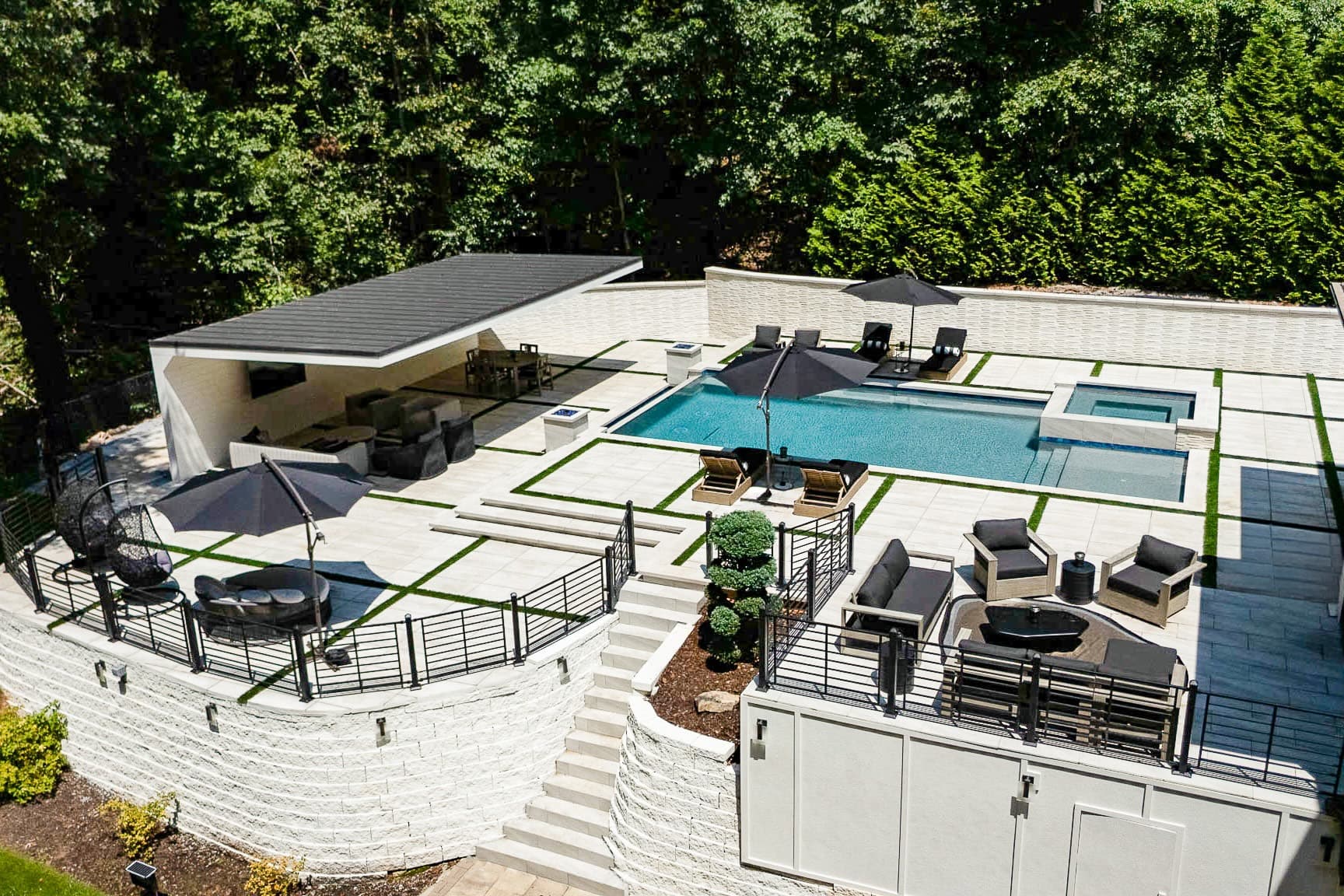 Aerial view of a Buckhead backyard with a custom pool, spa, pavilion, and outdoor terraces